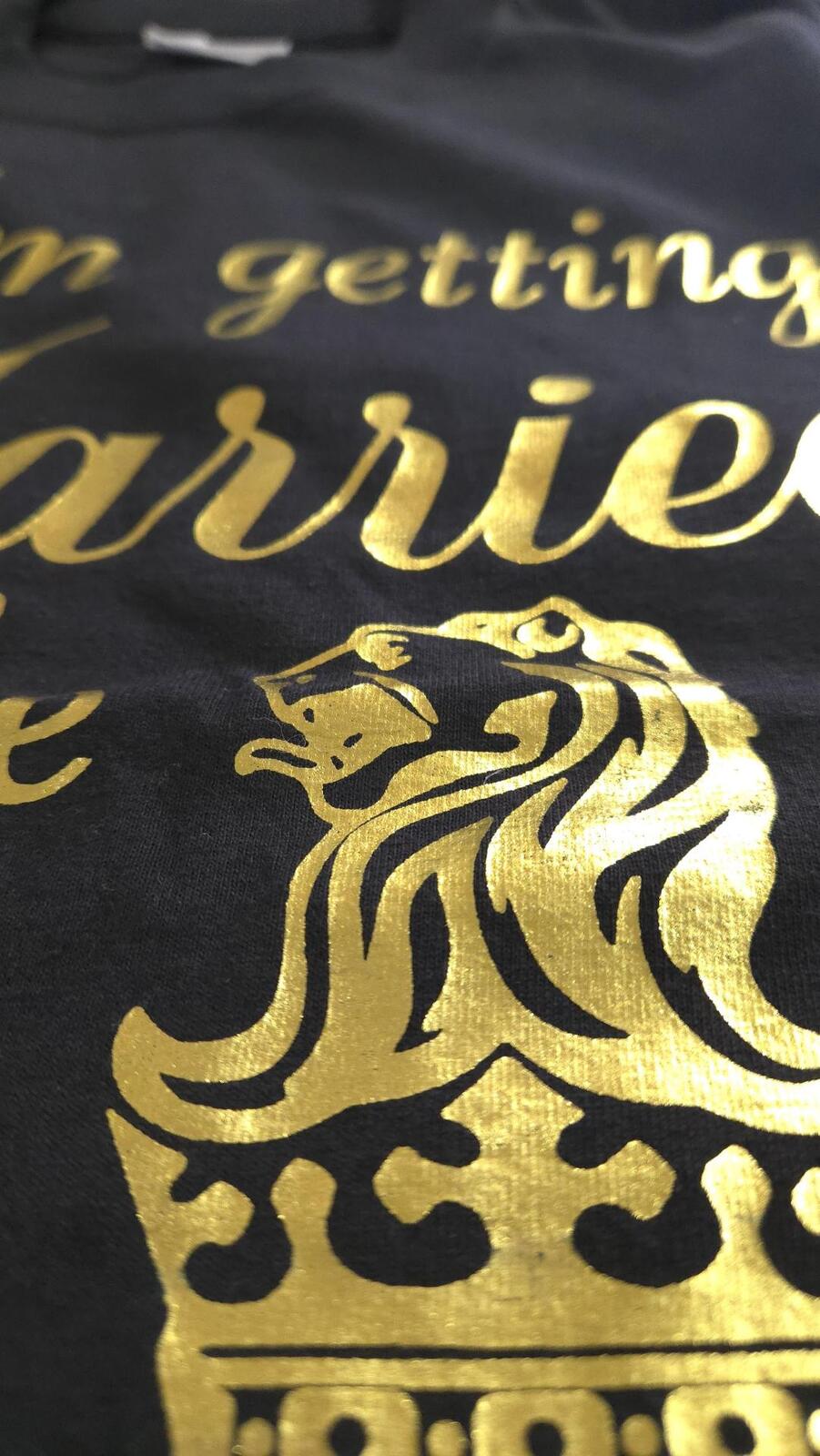 Close-up of glossy foil print on fabric, showing a reflective, mirror-like surface used for high-impact apparel decoration.